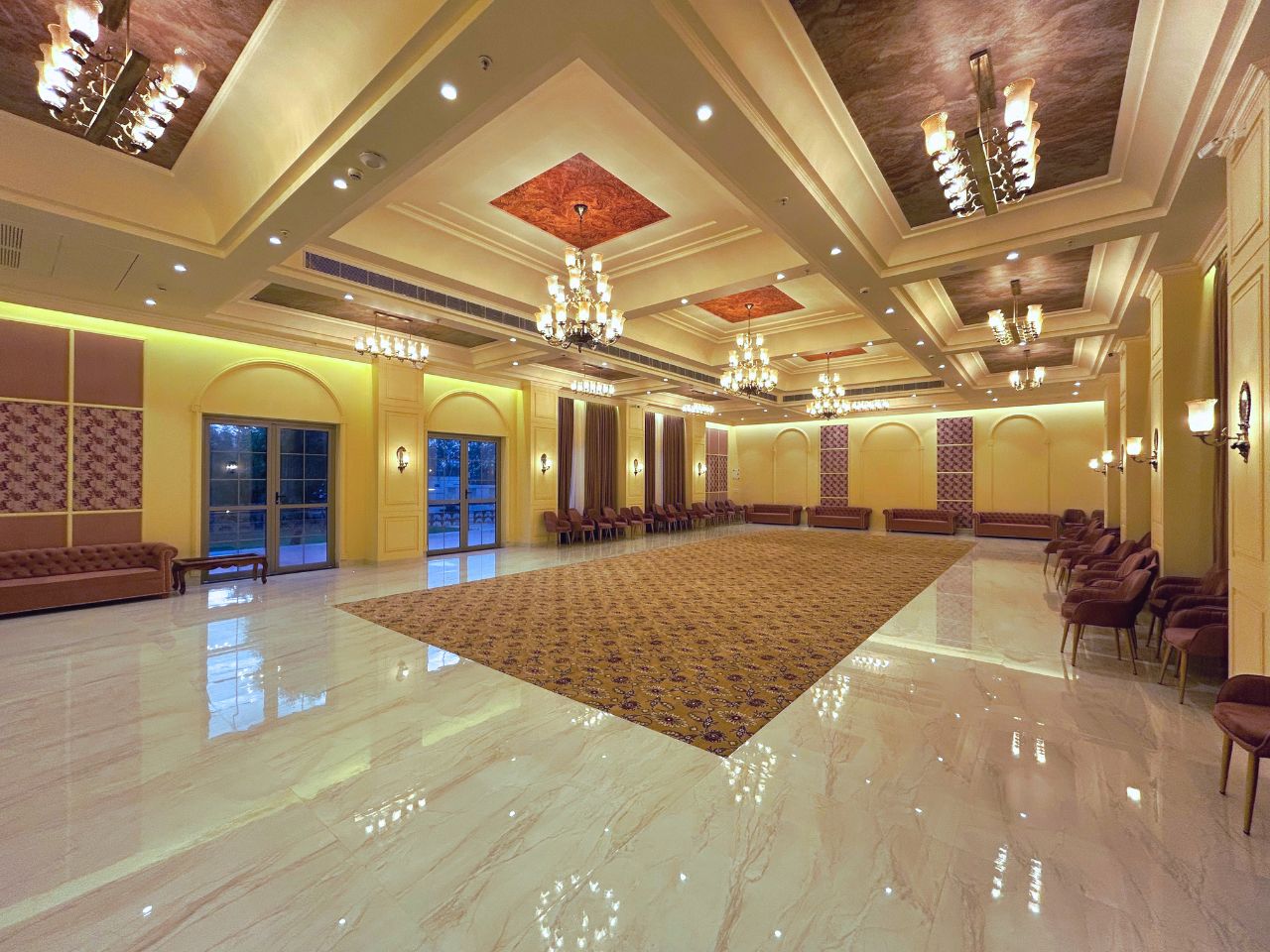 Elegant banquet hall with chandeliers and carpeted aisle at Vankamal, Jaipur