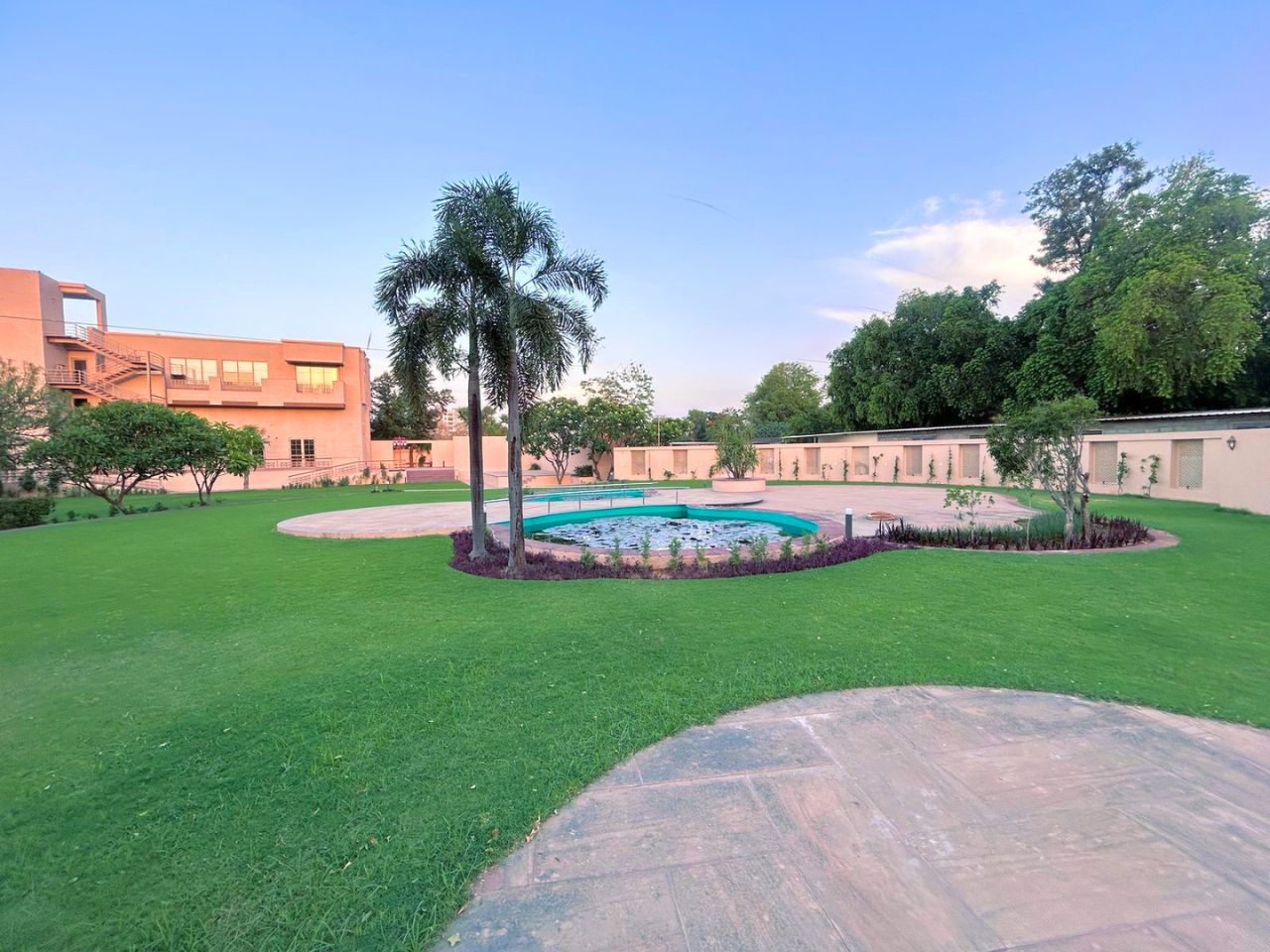 Garden lotus pond with palm tree at Vankamal Resort, Jaipur