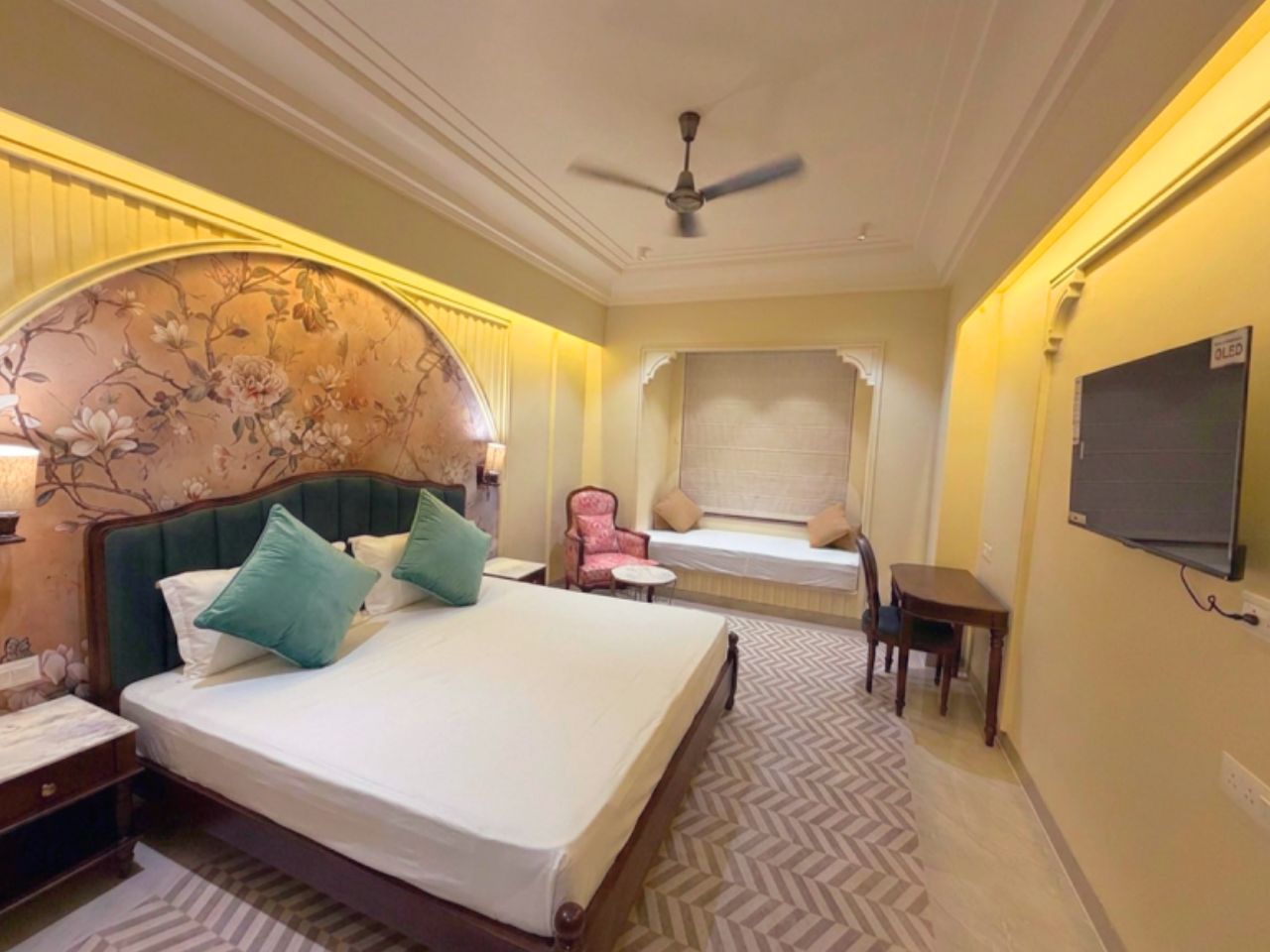 Luxury hotel room bed with floral headboard at Vankamal, Jaipur